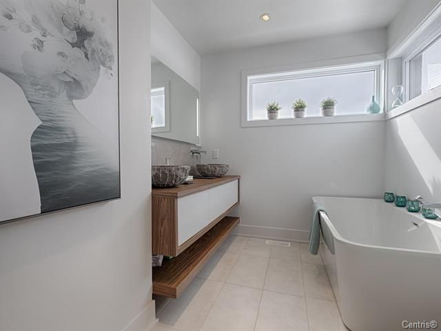 Une salle de bain avec deux vasques et une baignoire.