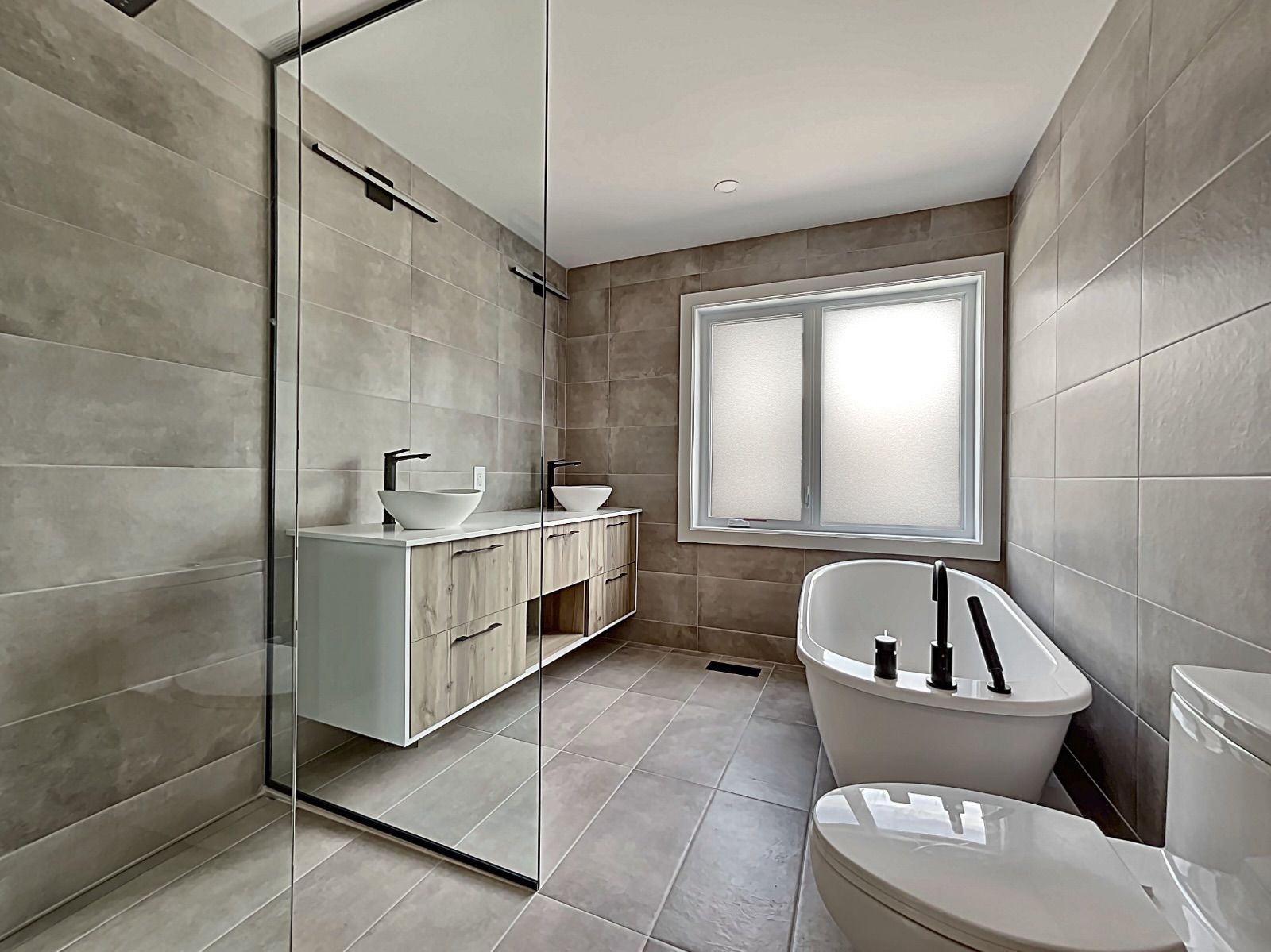 Une salle de bain avec baignoire , WC , lavabo et douche.