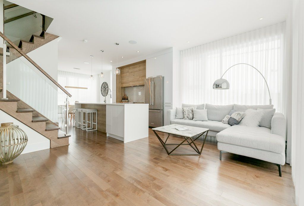 Un salon avec un canapé, une table basse et des escaliers.