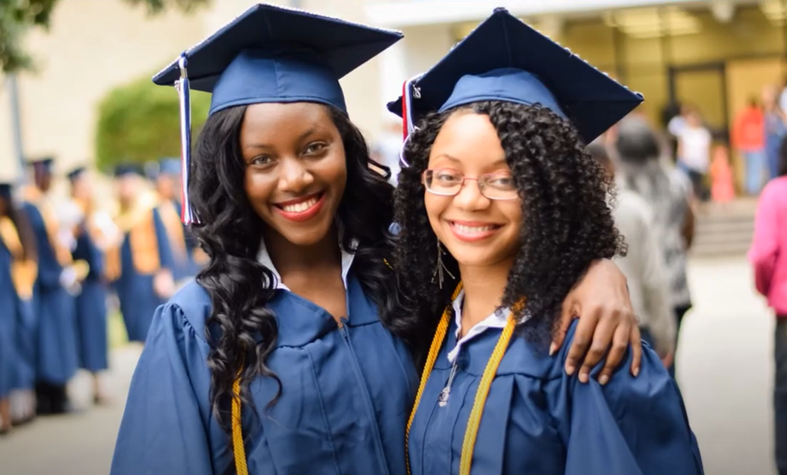 Two female graduates are posing for a picture together.