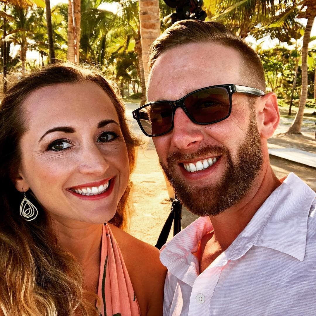 A man and a woman wearing sunglasses are smiling for a picture.