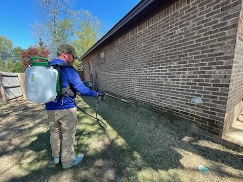 A lawn with trees in the background and a bird feeder in the middle of it.