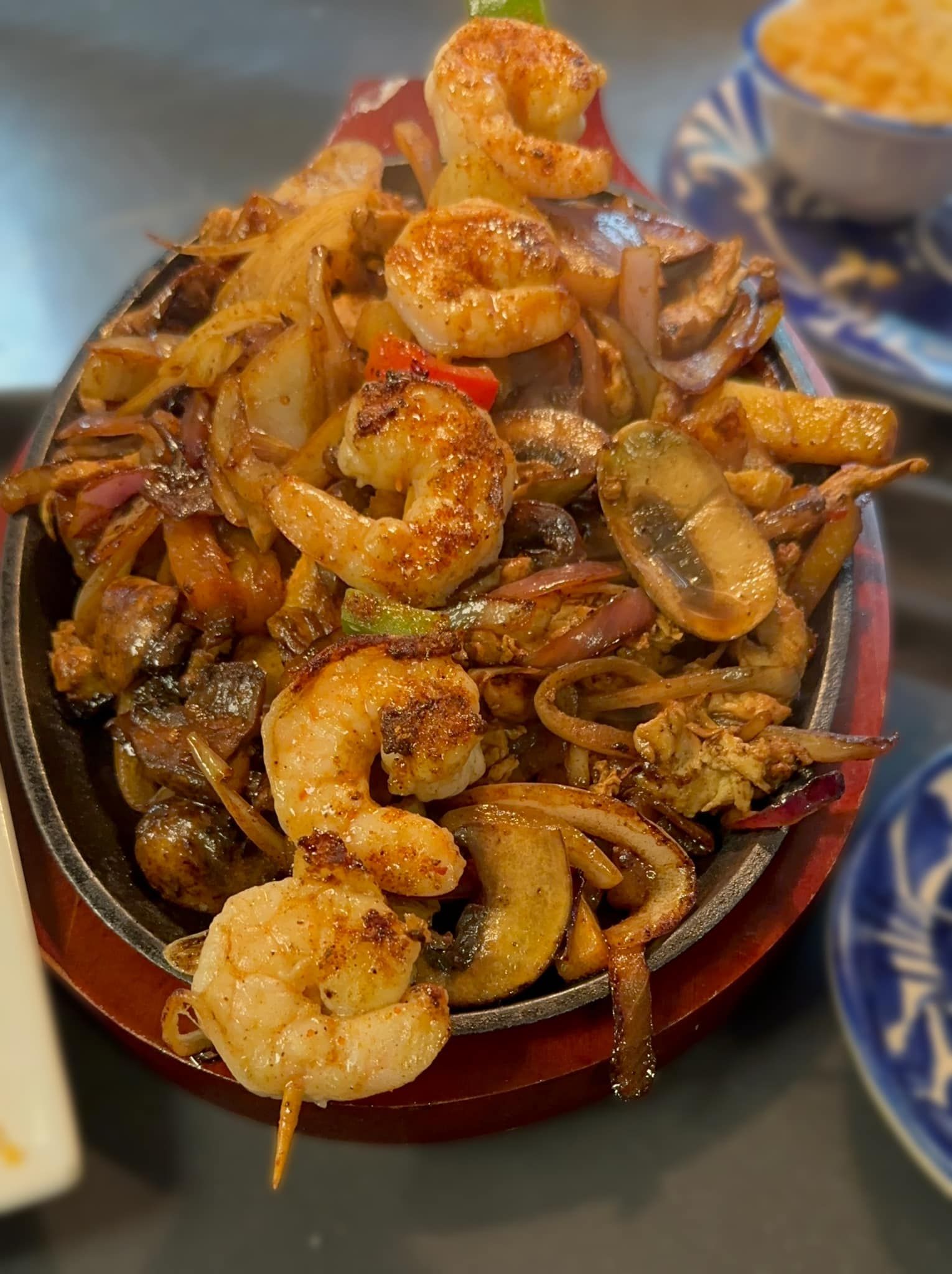 A plate of food with shrimp mushrooms and onions on a table