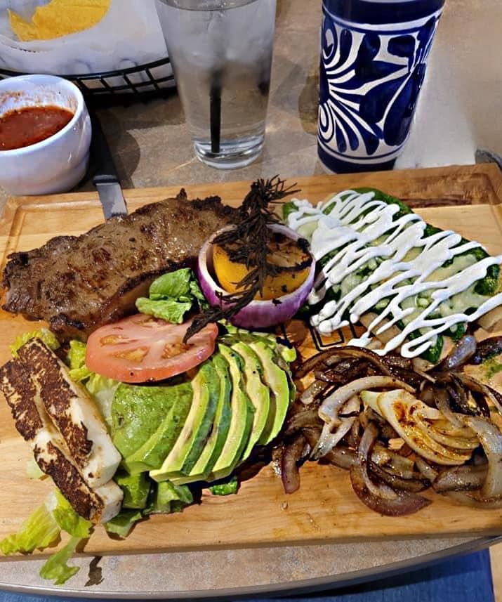 A plate of chips and a bowl of dip on a table