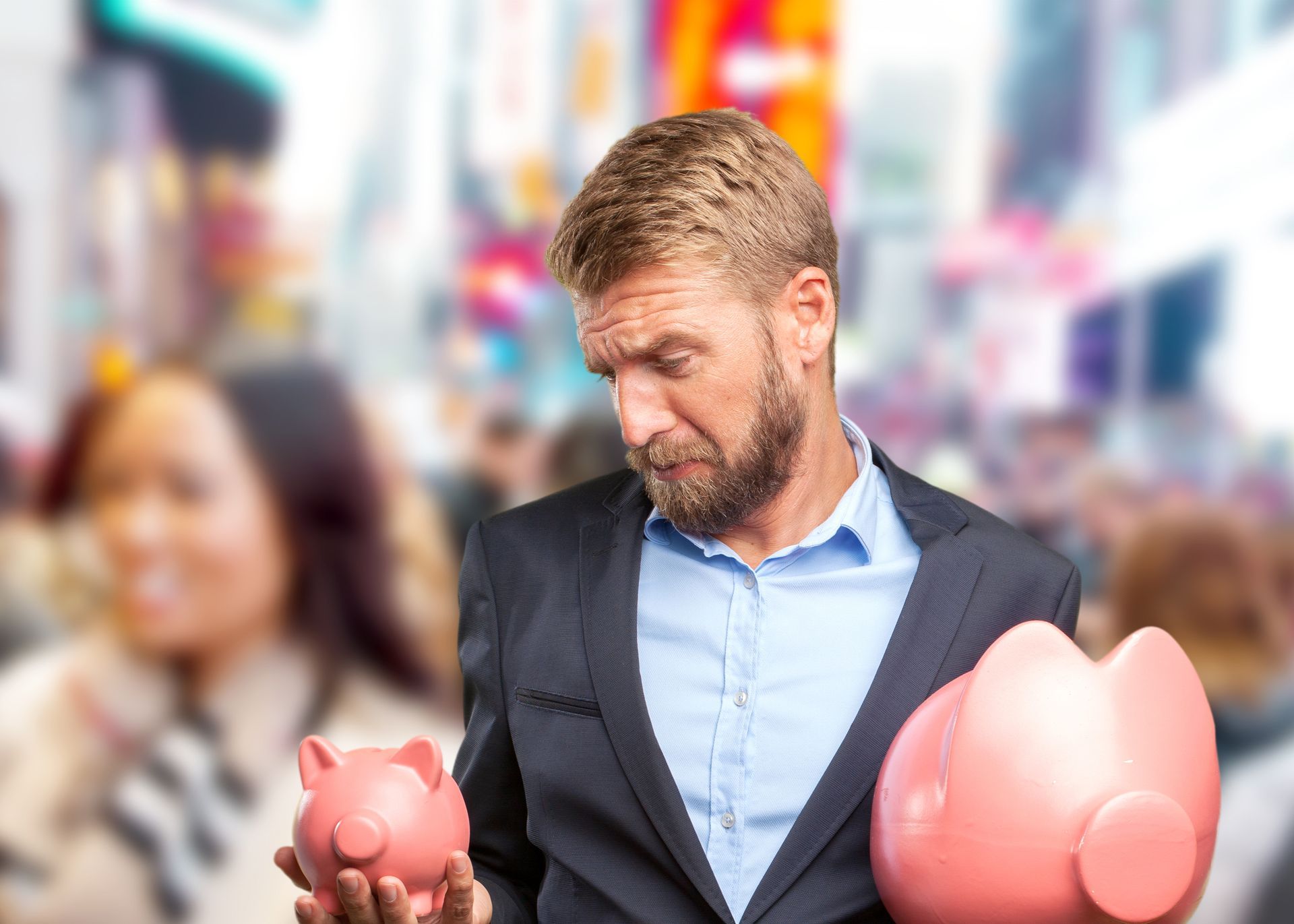 A man in a suit is holding two piggy banks in his hands.