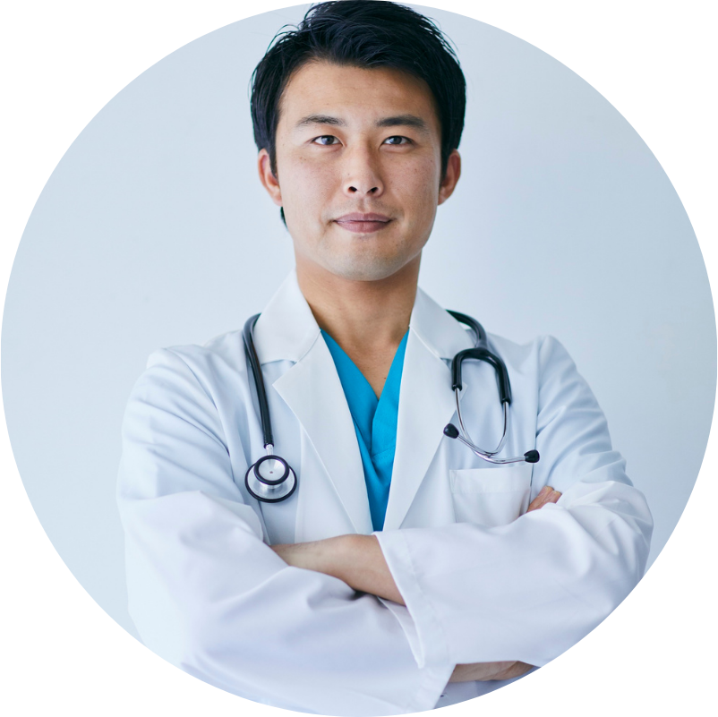 Doctor with folded arms, wearing a stethoscope and white coat, in a clinical setting.