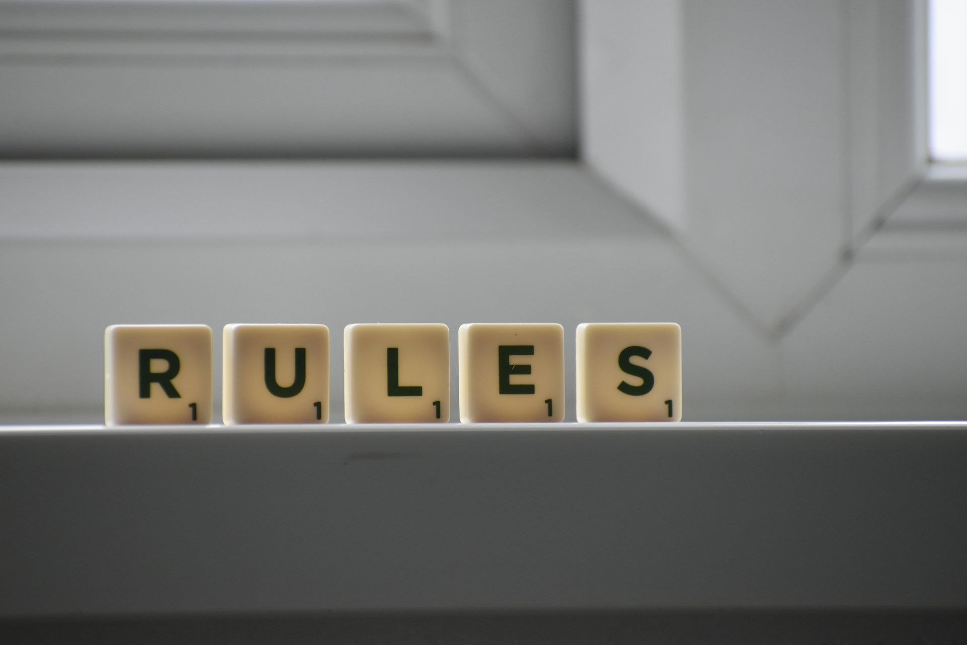 A row of scrabble tiles spelling out the word rules