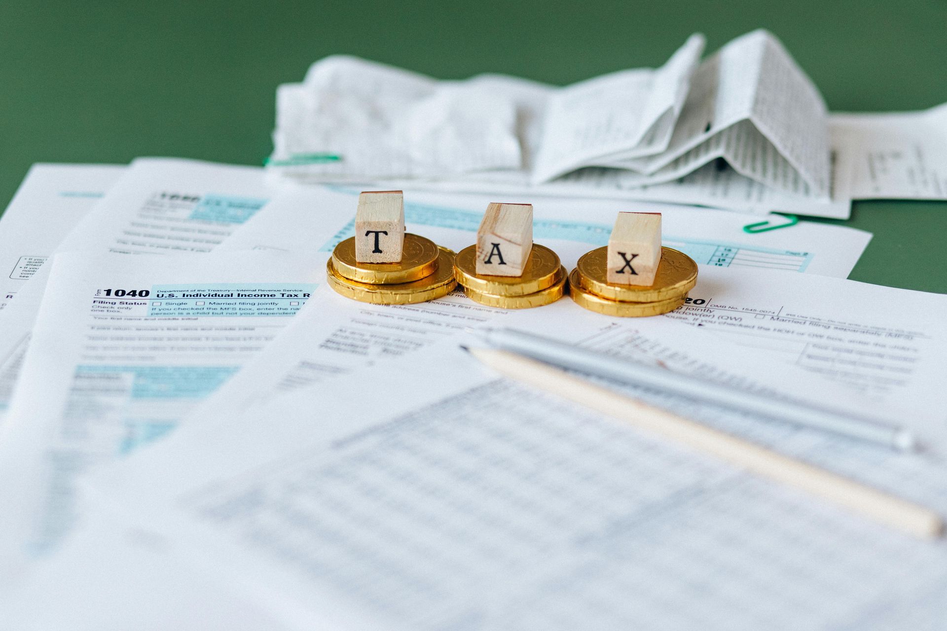 A pile of papers and coins with the word tax written on them.