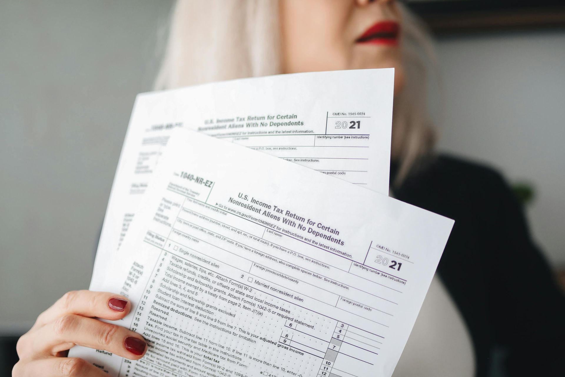 Woman holding tax forms.