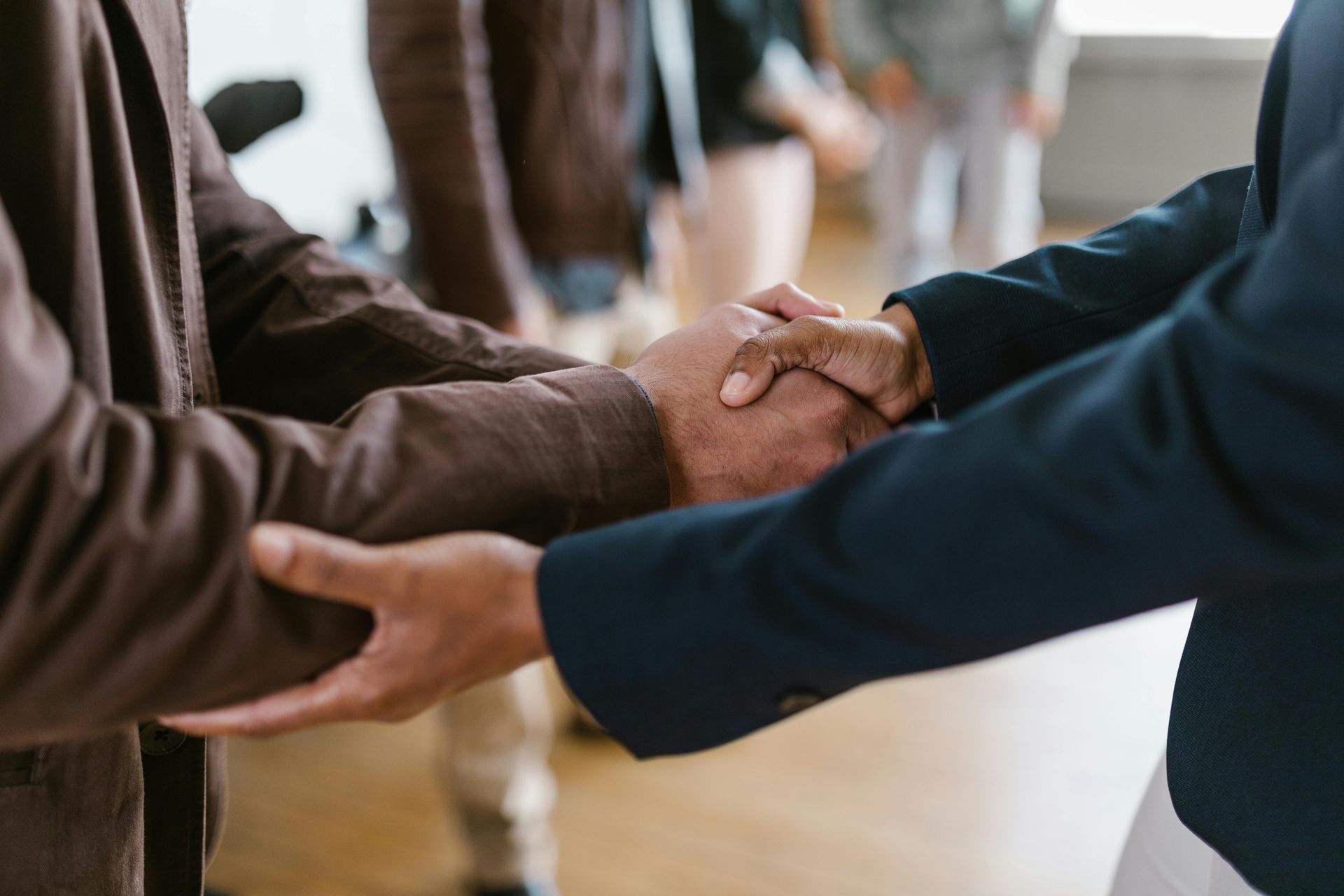 Two people in suits shaking hands.