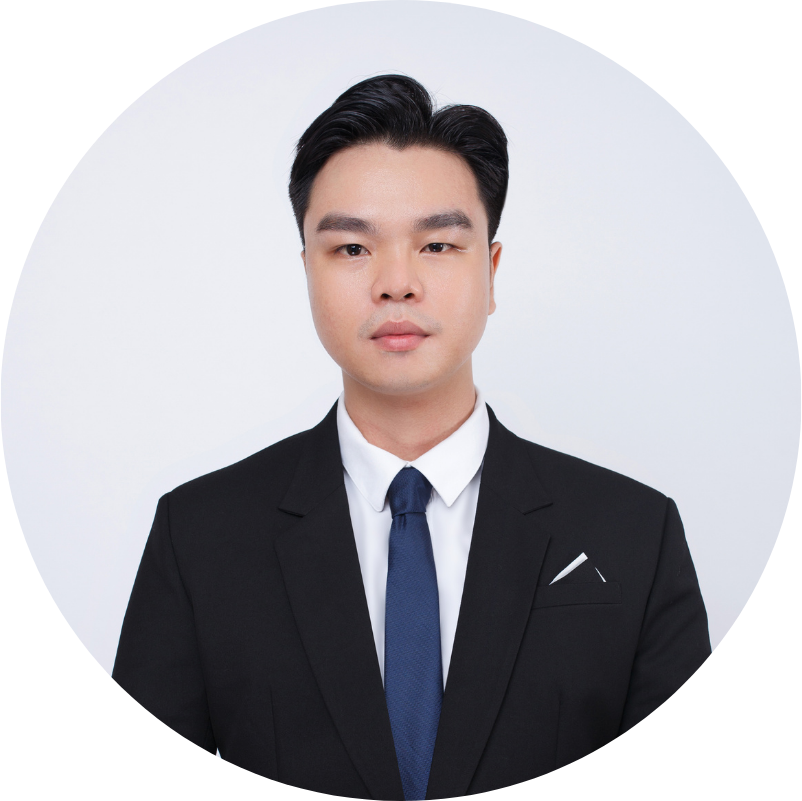 Man in a black suit and blue tie, looking directly at the camera against a white backdrop.