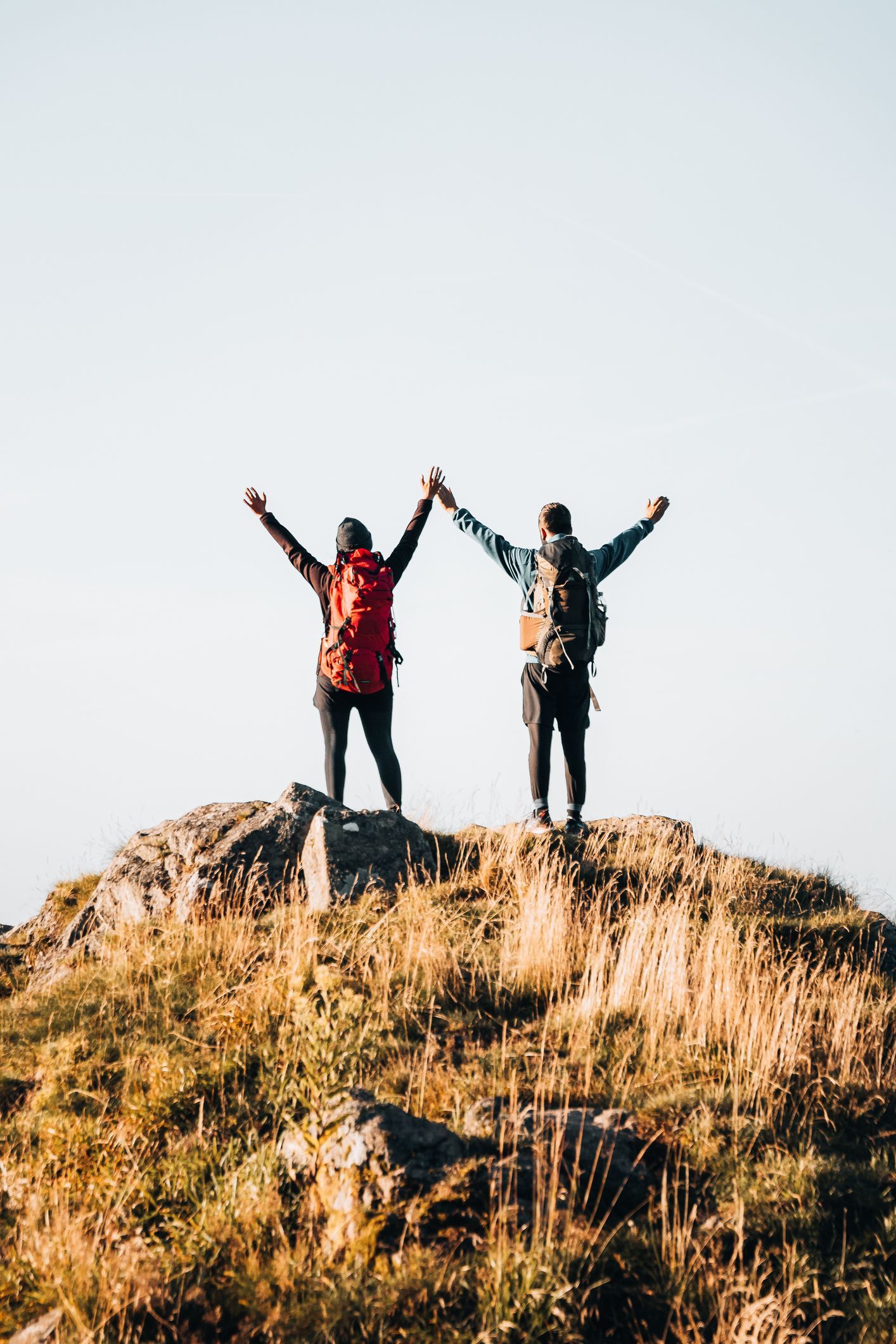 A man in a red shirt is holding a clipboard in a gym.