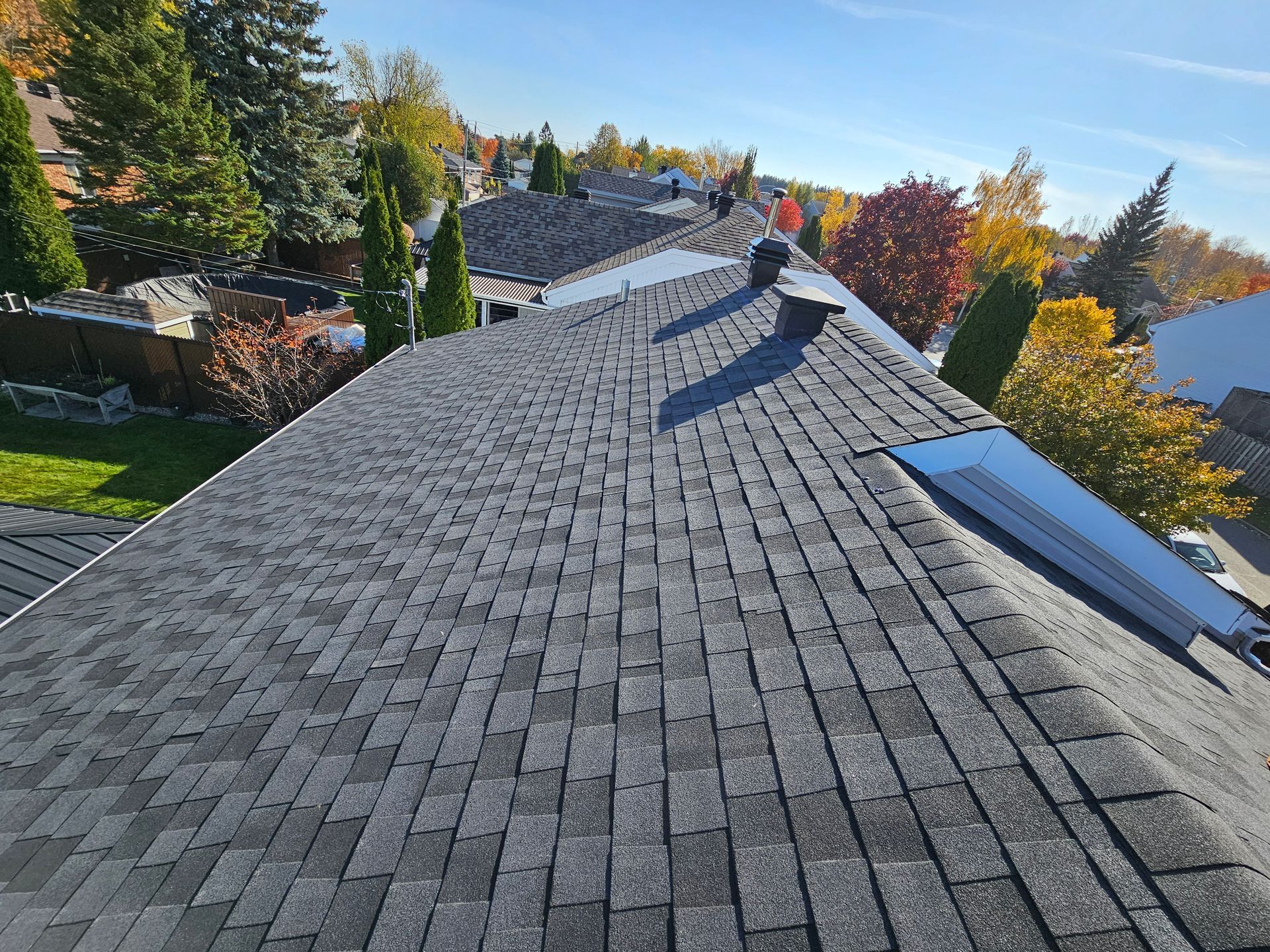 Le toit d'une maison avec un toit en bardeaux et une lucarne.