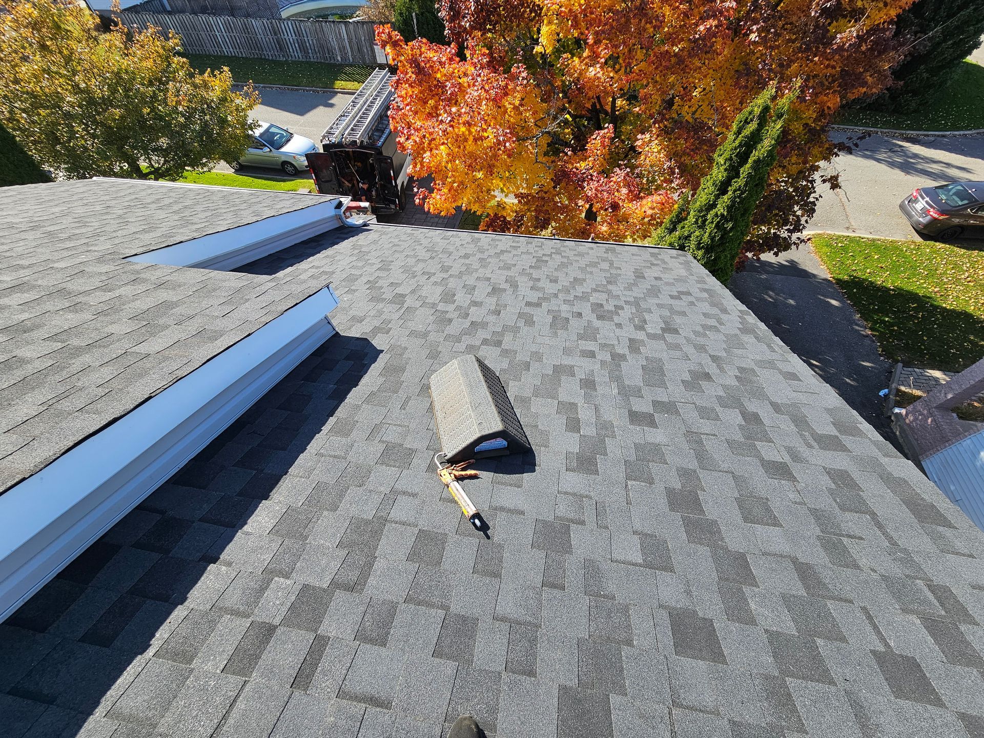Une personne se tient sur un toit avec un outil dessus.