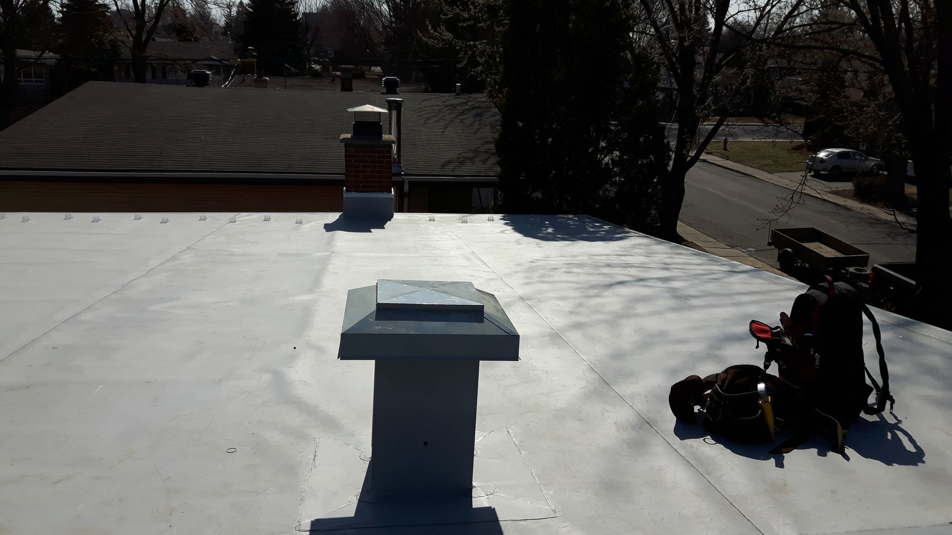 Un toit blanc avec une cheminée au-dessus.