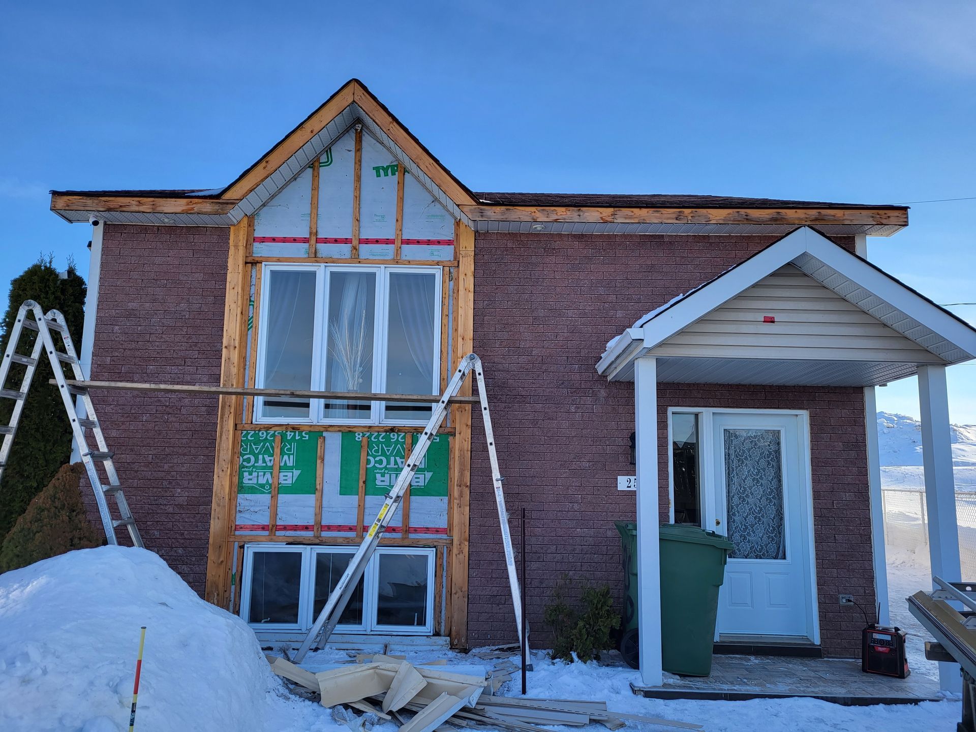 Une maison en briques est en cours de rénovation sous la neige.