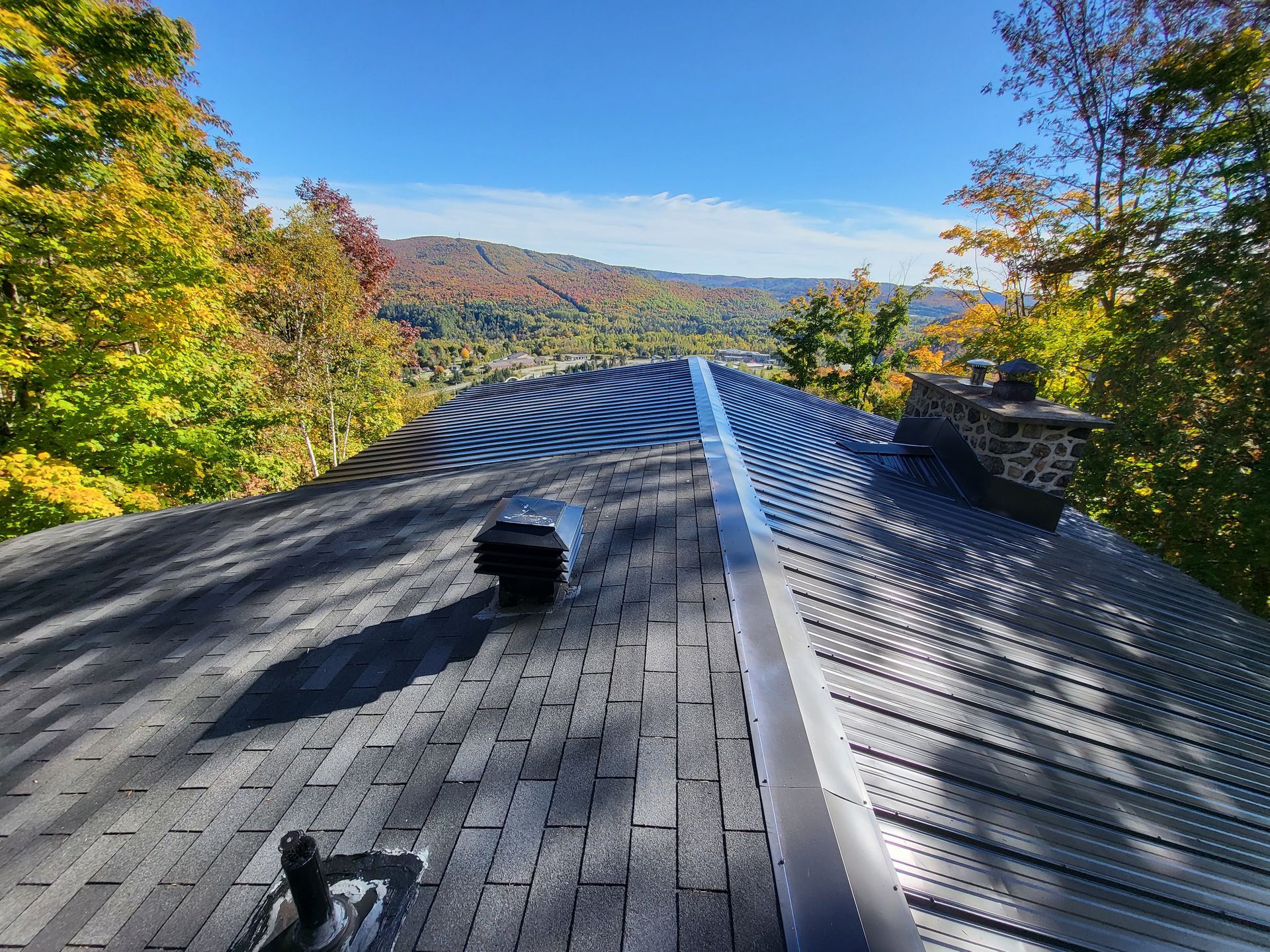 Le toit d'une maison avec vue sur les montagnes et les arbres.