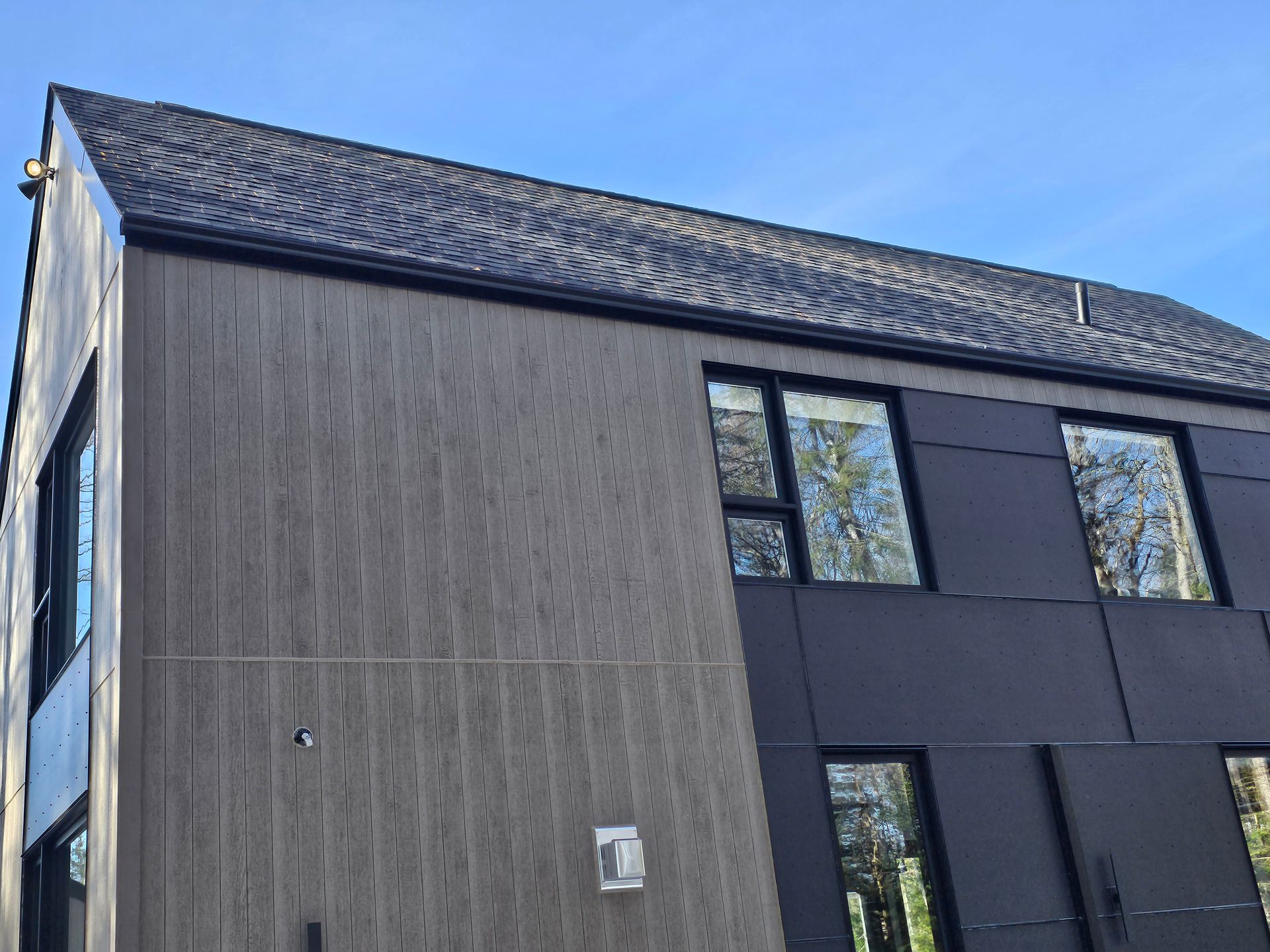 Un grand bâtiment avec un toit et beaucoup de fenêtres.