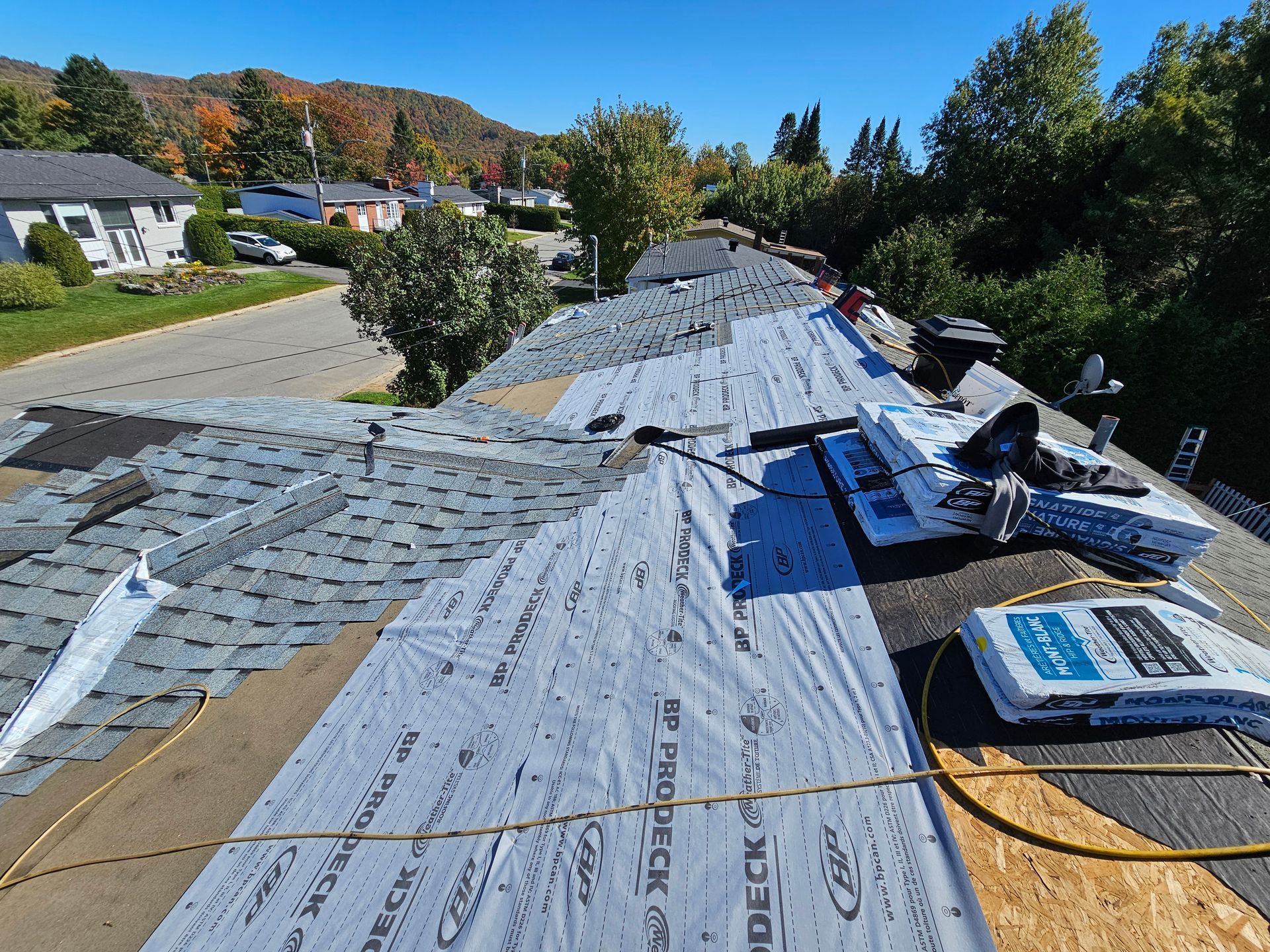 Un toit est en cours de réparation par une journée ensoleillée.