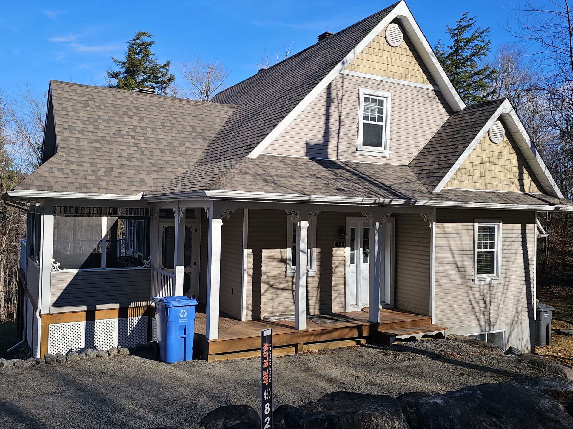 Une maison avec une poubelle bleue devant