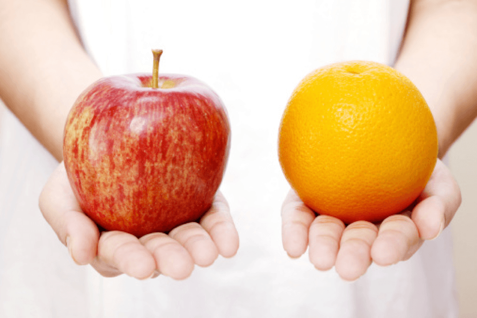Person holds out an apple in one hand and an orange in the other.
