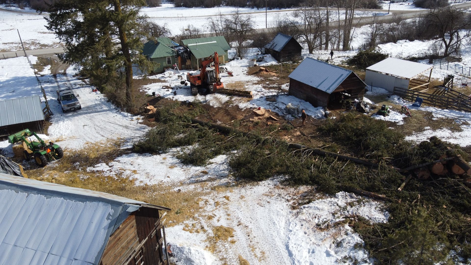 An aerial view of a snowy field with a lot of trees and buildings.