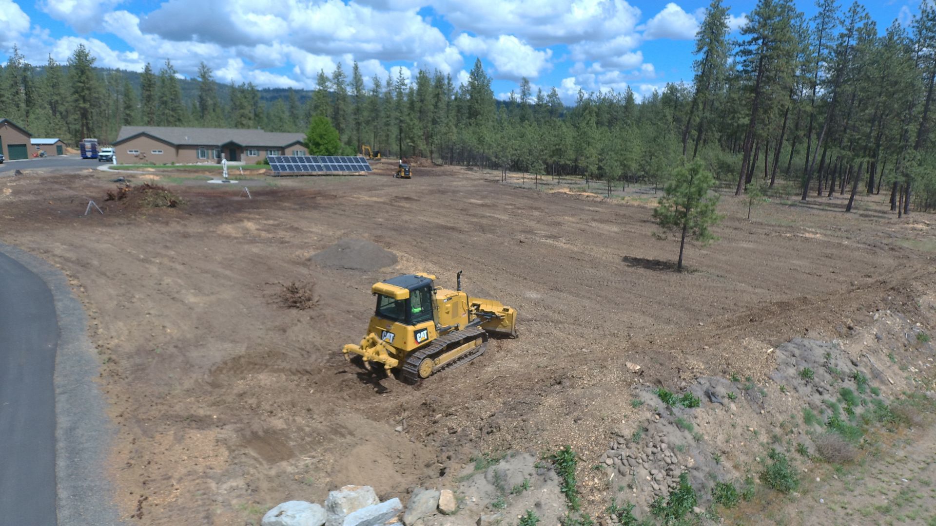 An aerial view of a bulldozer working on a dirt field.