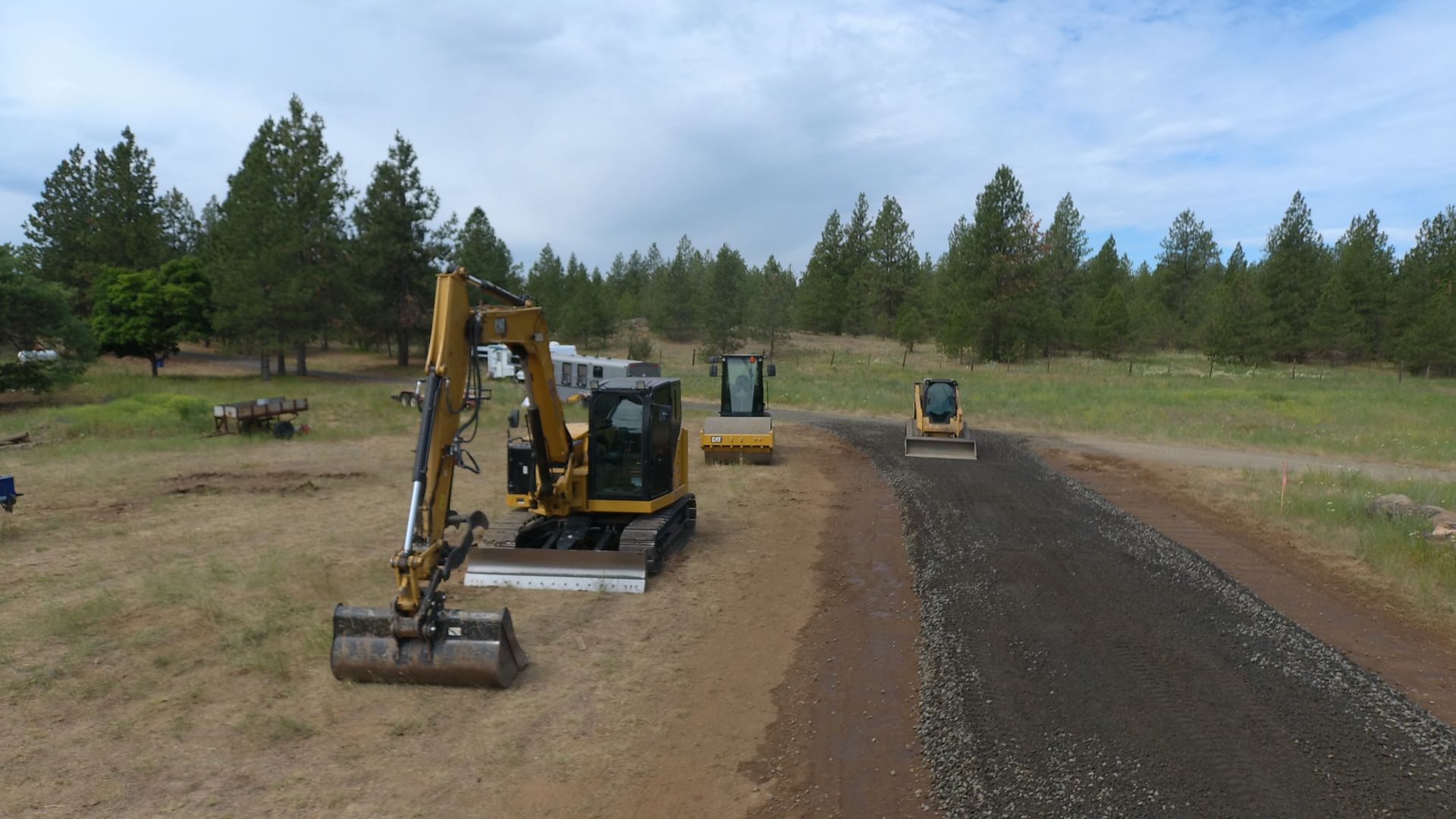 A group of construction vehicles are working on a road.