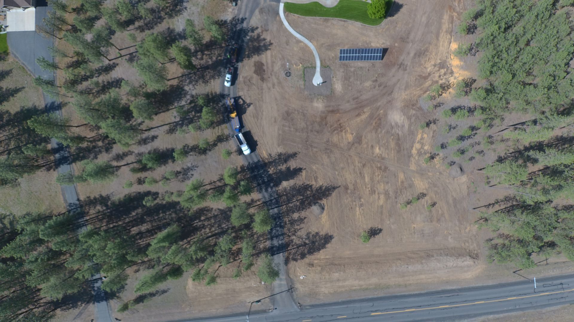 An aerial view of a house surrounded by trees and a road.
