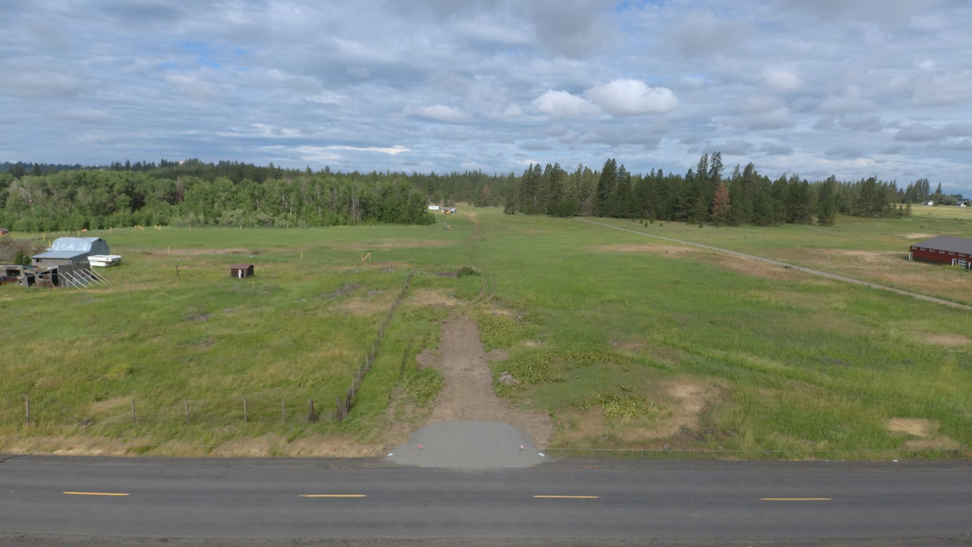 An aerial view of a grassy field next to a road.