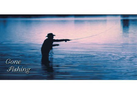 a silhouette of a man fishing in a lake .