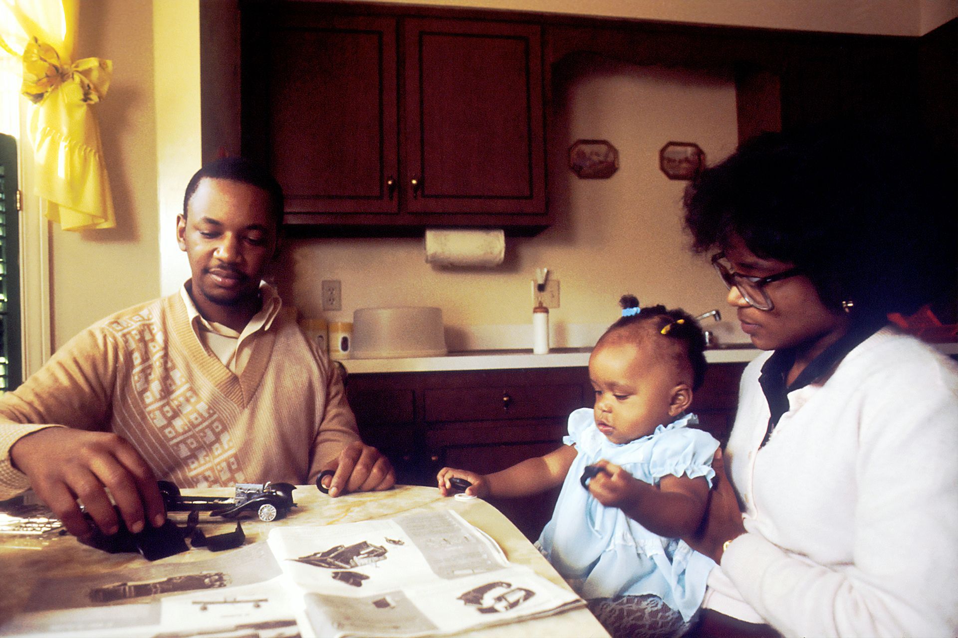 a man and woman are sitting at a table with a baby