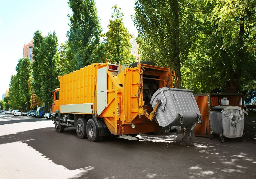 A Yellow Garbage Truck Is Parked On The Side Of The Road — Green Solutions Qld Pty Ltd in Mulara, QLD