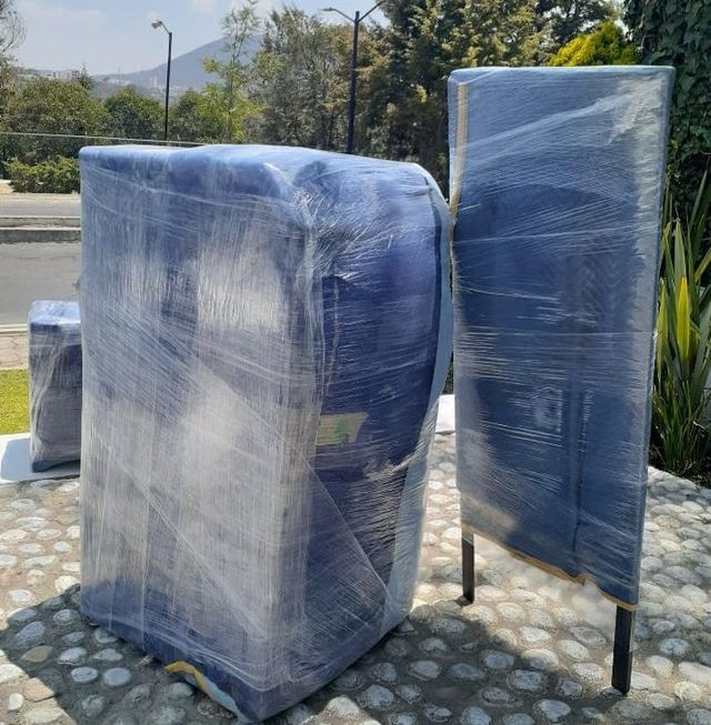 Dos sillas envueltas en plástico sentadas en una acera.