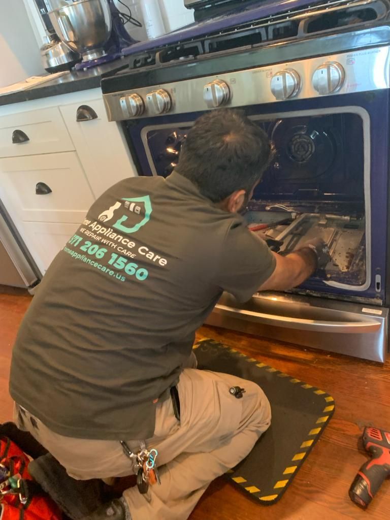 a man is working on a stove in a kitchen .
