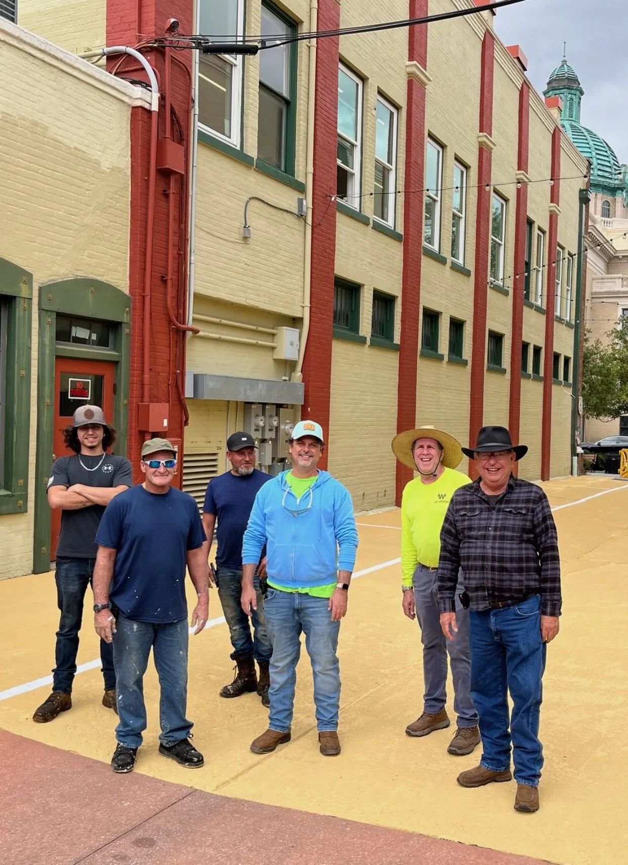 A group of men are standing in front of a building.