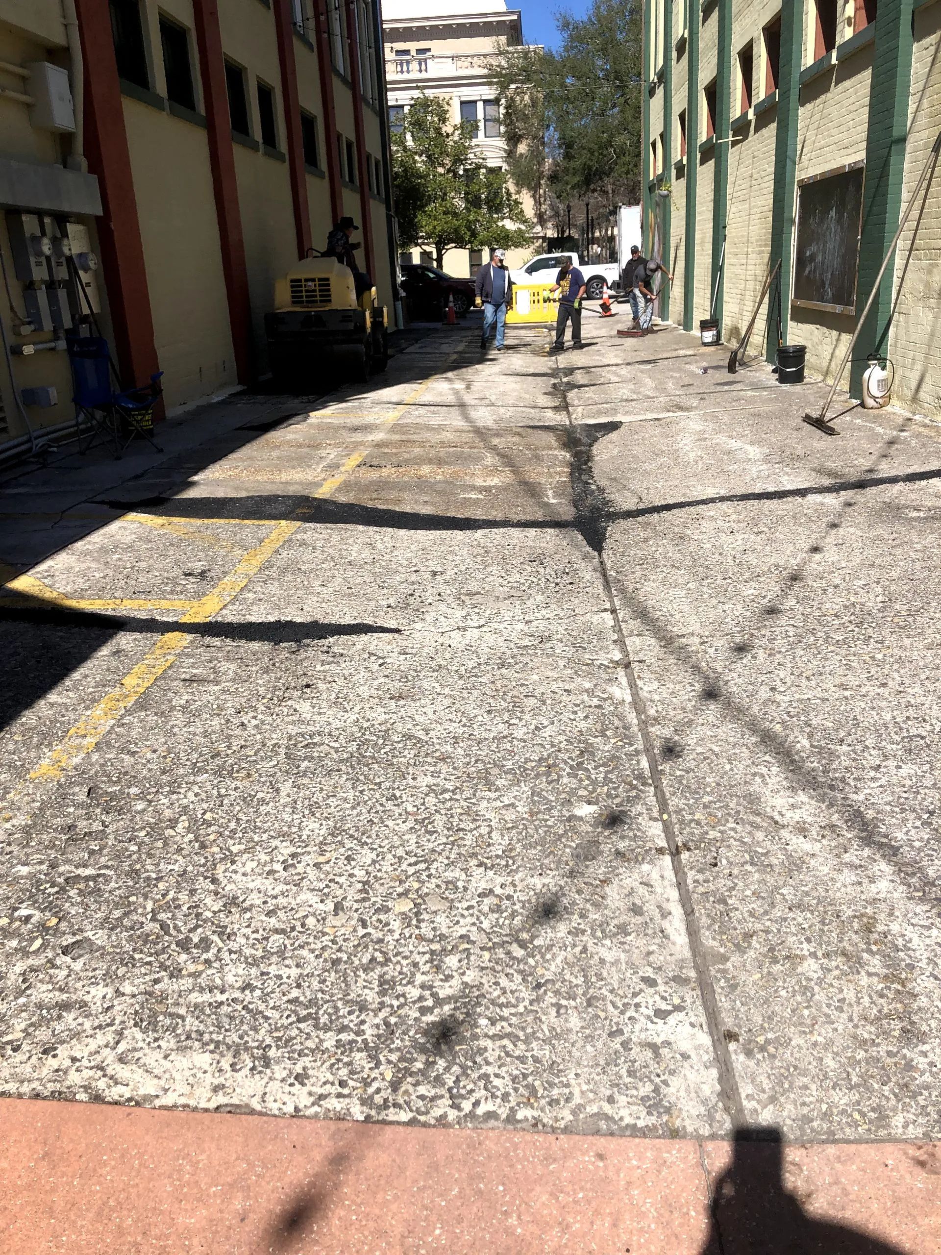 A shadow of a person is cast on the sidewalk in front of a building.