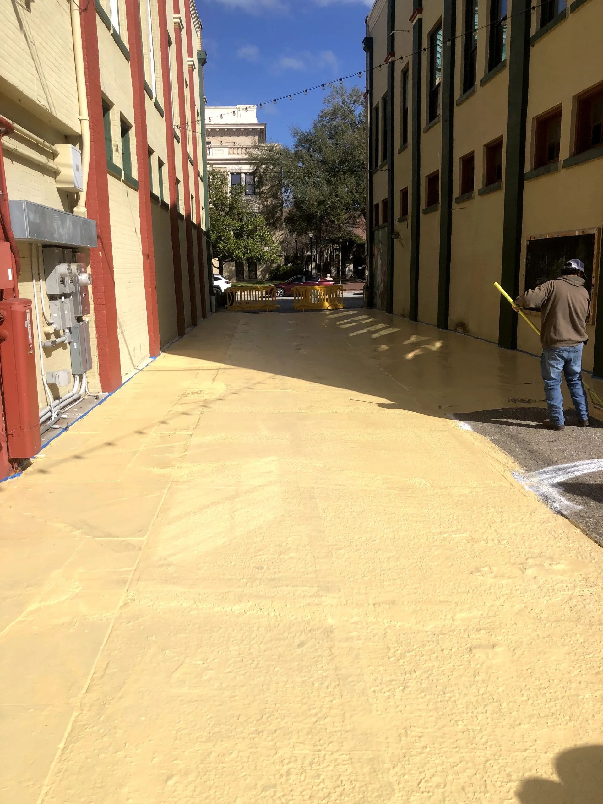 A man is standing in a narrow alleyway between two buildings.