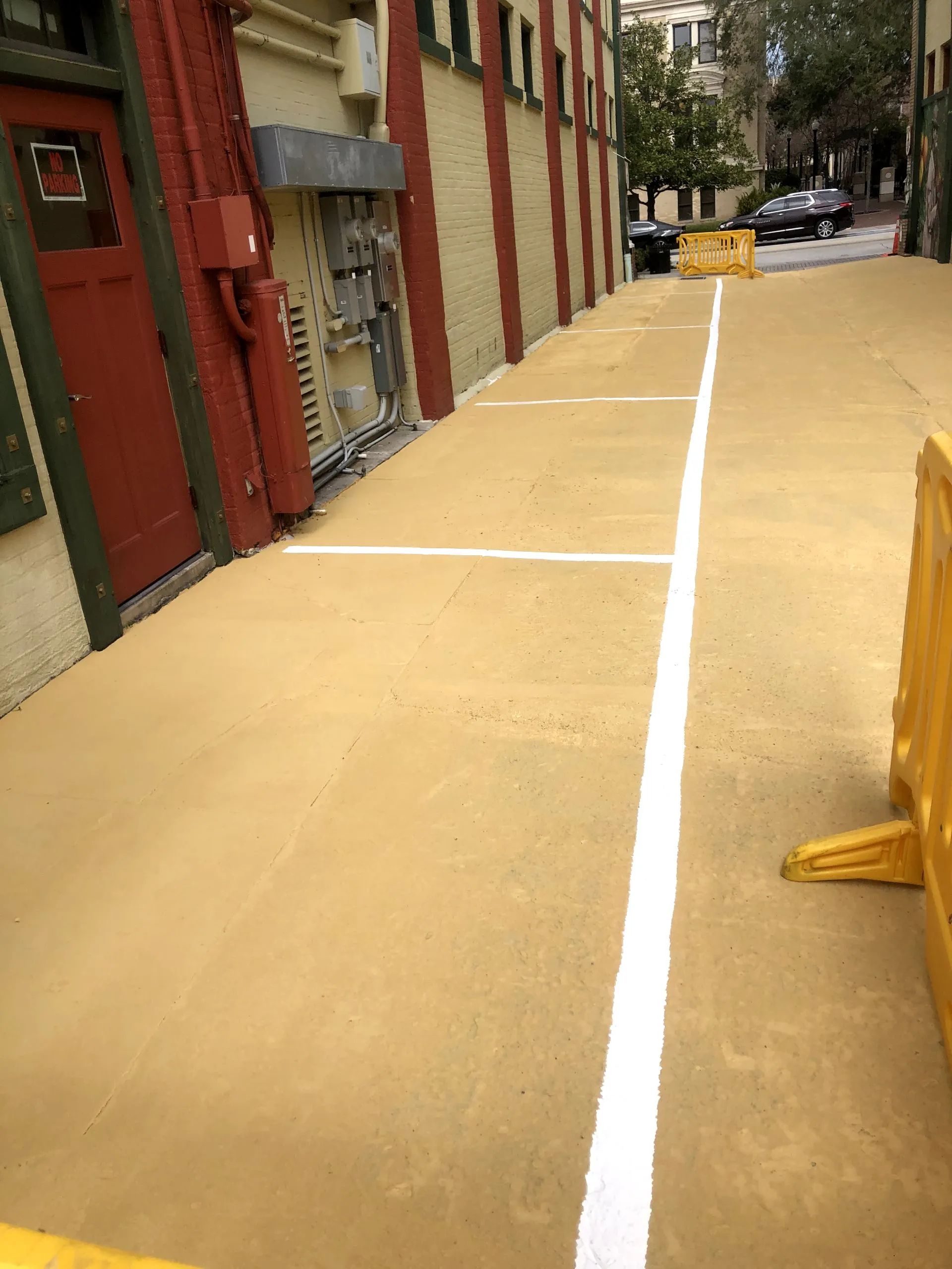A parking lot with white lines and a yellow barrier