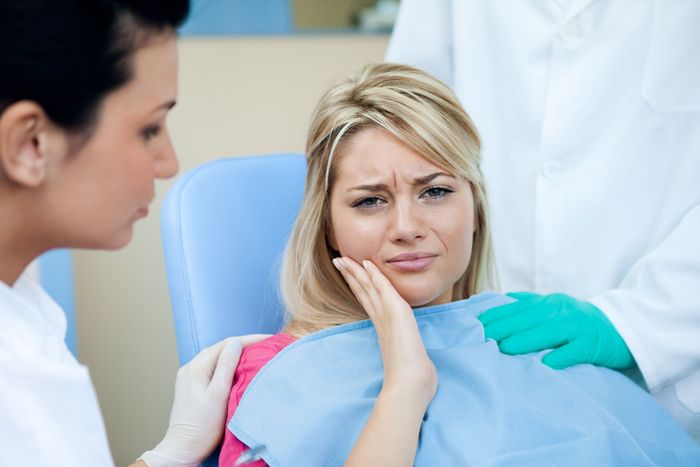 A woman is sitting in a dental chair with a toothache — Hobart, TAS — Moonah Dental Centre