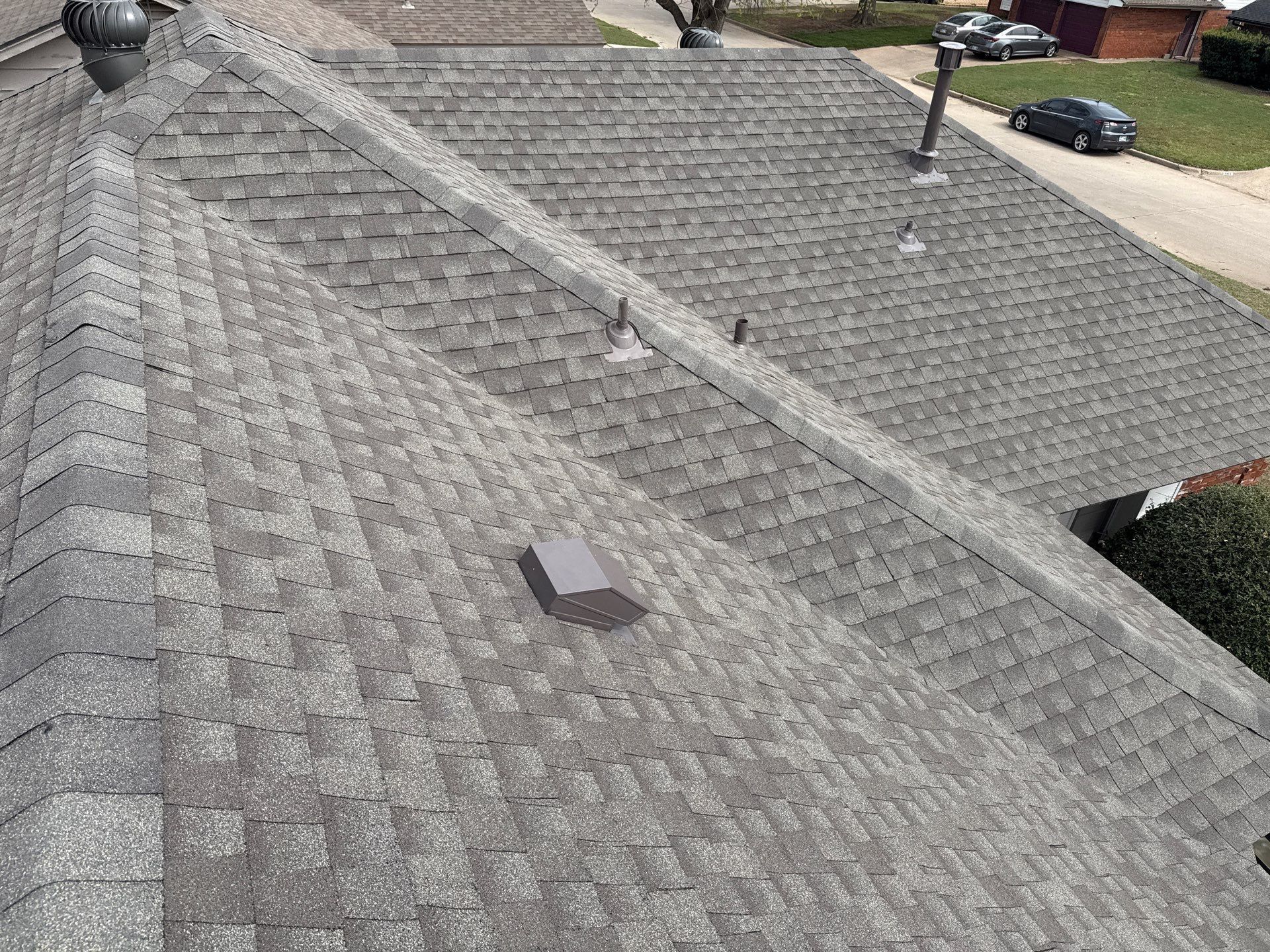 A roof with a lot of shingles and a chimney on it.