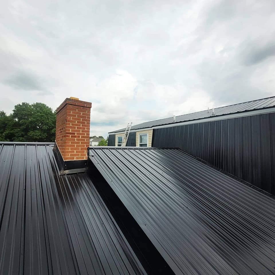 Metal roof with a gutter, overcast sky, residential setting.
