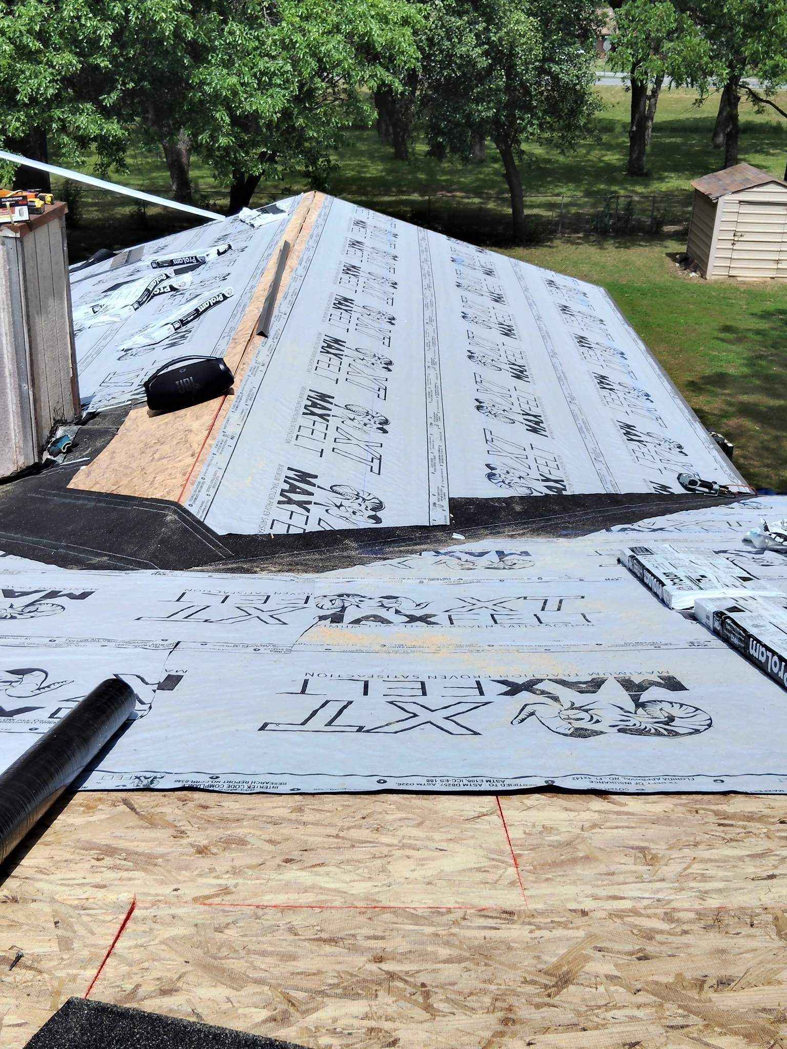 A roof is being installed on a house with a chimney.