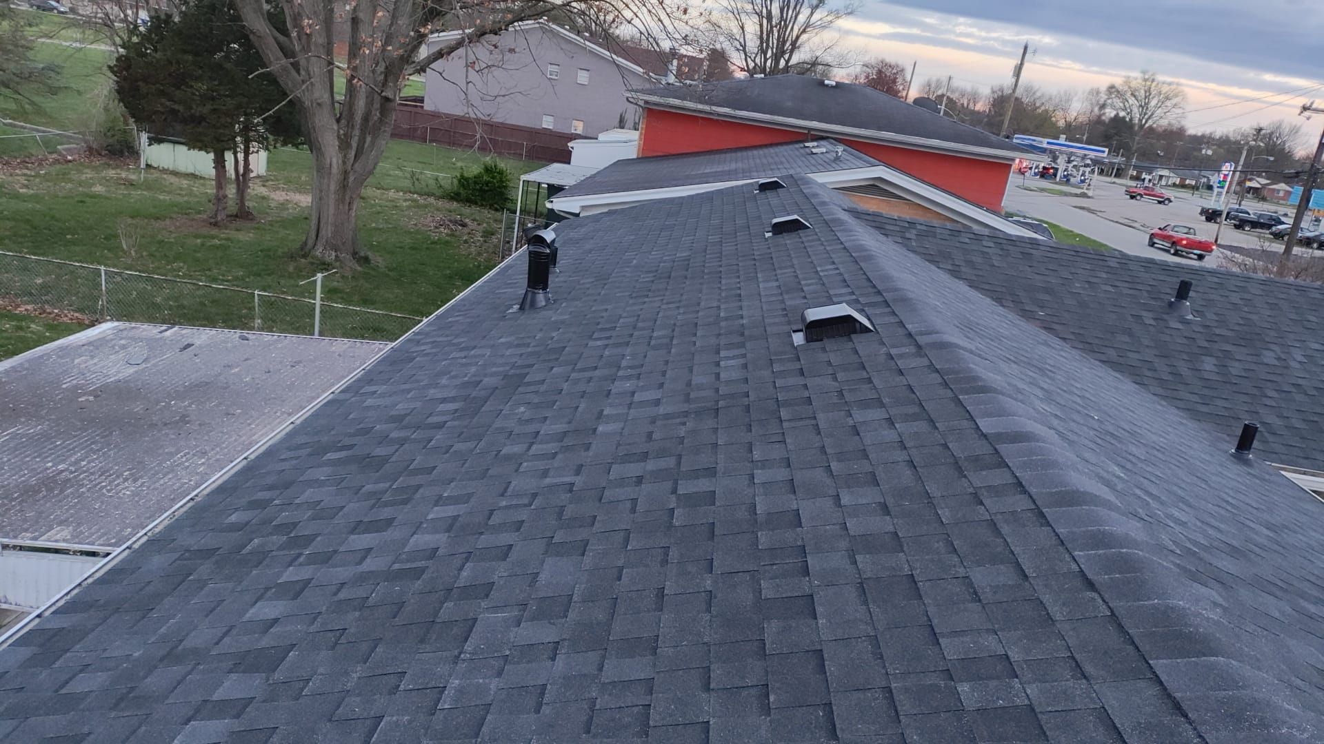 A roof with a lot of shingles on it is being installed on a house.