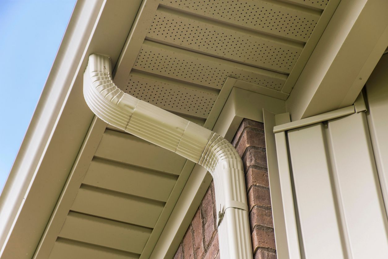 A close up of a gutter on the side of a house.