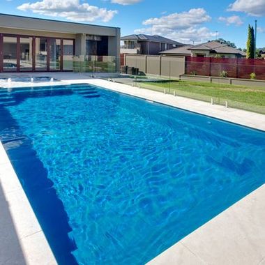 A large swimming pool with a house in the background — Azure Pools Mid North Coast In Taree, NSW