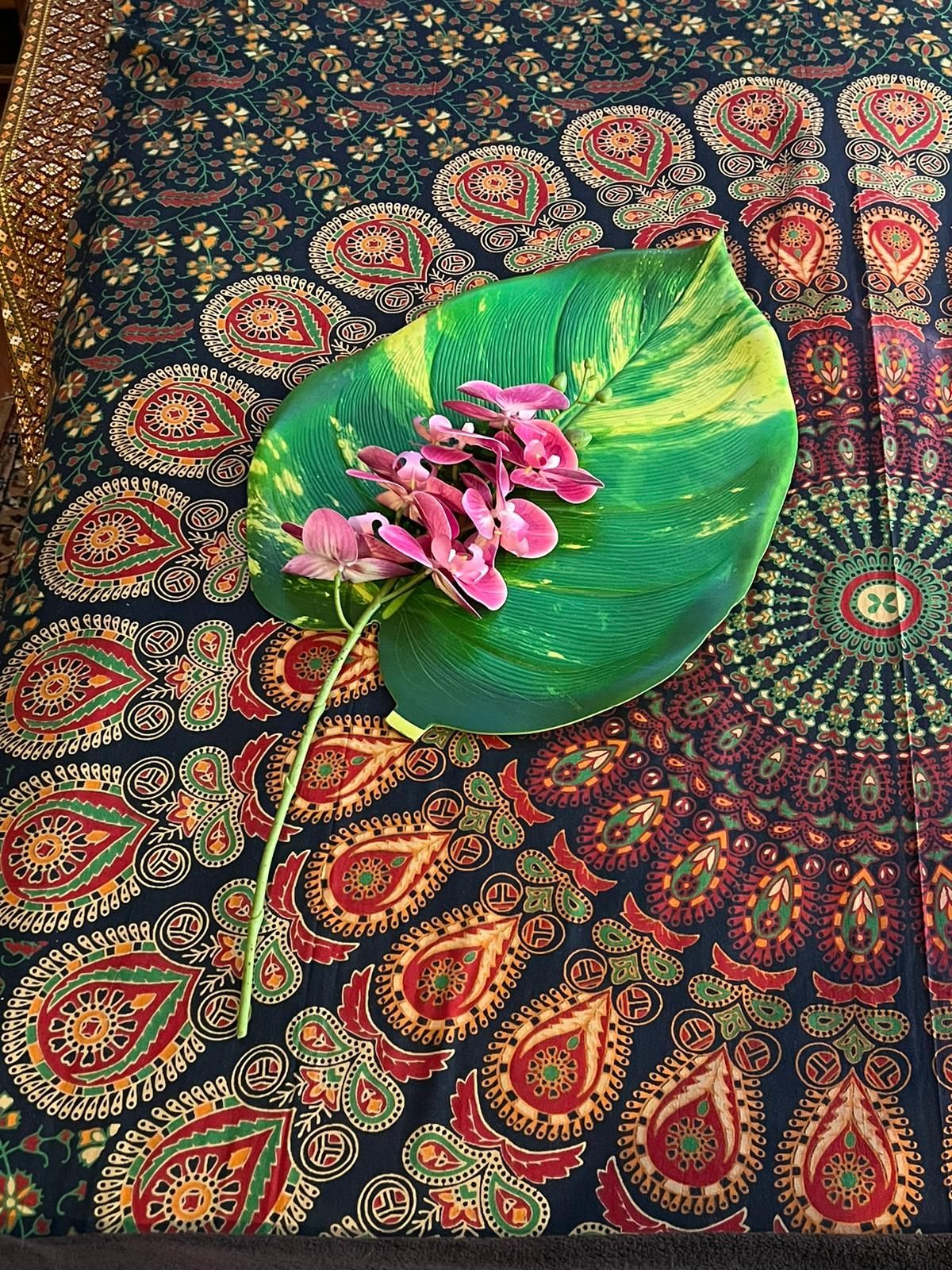 Beispiel aus der Innendekoration der Massage-Praxis: Ein buntes Tuch mit einem grünen Blatt und einer Pinken Blüte