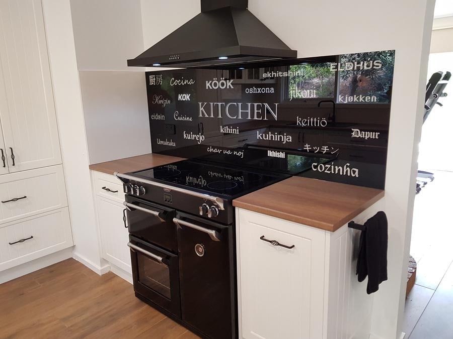 A Kitchen With a Black Stove Top Oven and White Cabinets — DecoGlaze in Camden, NSW