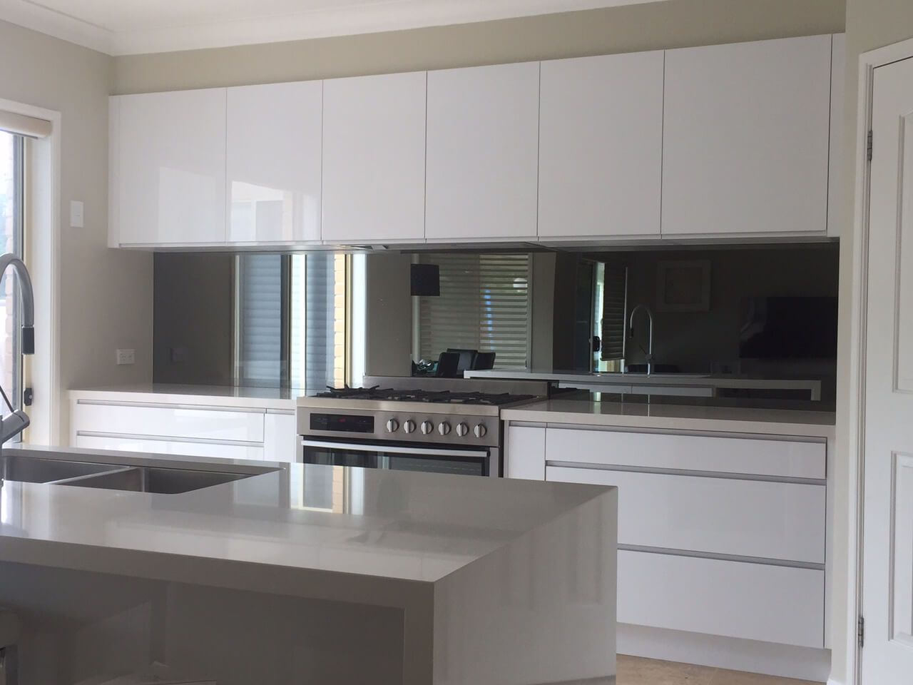 A Kitchen With White Cabinets, Stainless Steel Appliances, a Sink, and a Large Island — DecoGlaze in Minchinbury, NSW