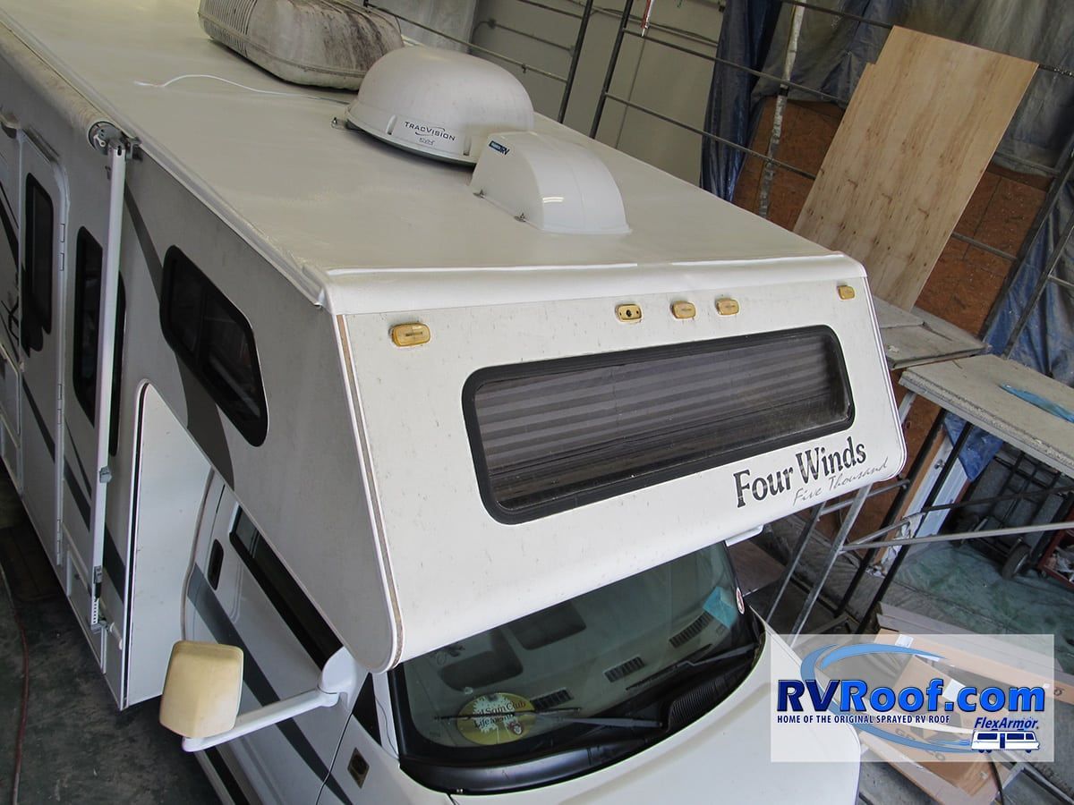 A white four winds rv is parked in a garage
